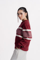 Woman wearing a red sweater with white stripes on a white background