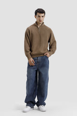 Man wearing a brown sweater and blue jeans on a white background